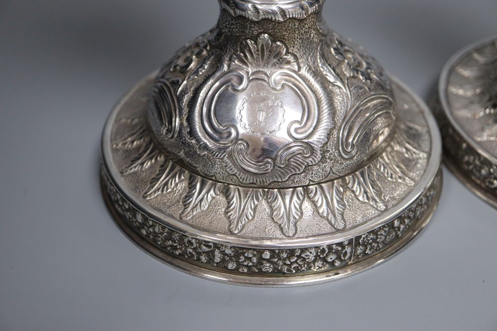 A pair of late George III silver candlesticks, with later embossed decoration, Soloman Hougham, London 1817,